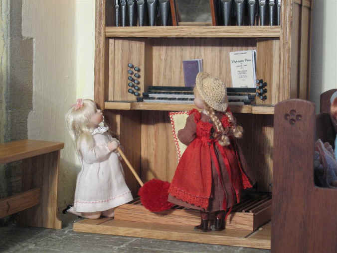 Adele and Priscilla Jane clean the two manual pipe organ in the church.