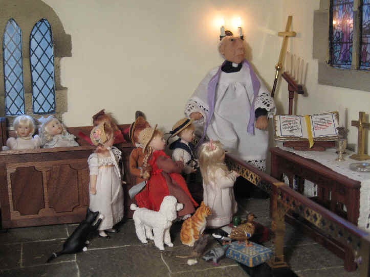 The vicar is in the sanctuary as he explains all about the Christmas colours to the children who are all in the chancel listening to him as well as some of the church pets and wildlife!