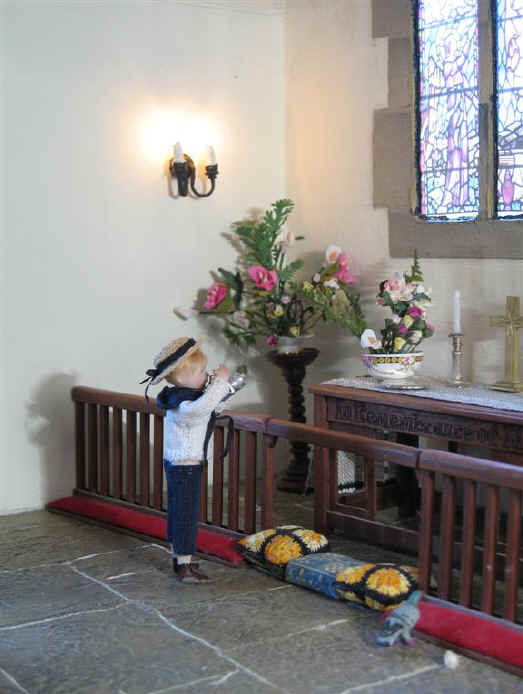 Tom is taking a photograph of the new stained glass window of St. Hilary's Miniature Church.